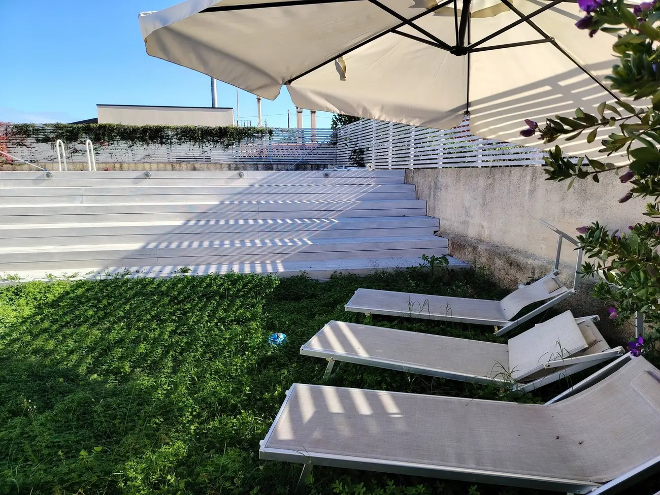 Lettini e ombrellone a bordo piscina